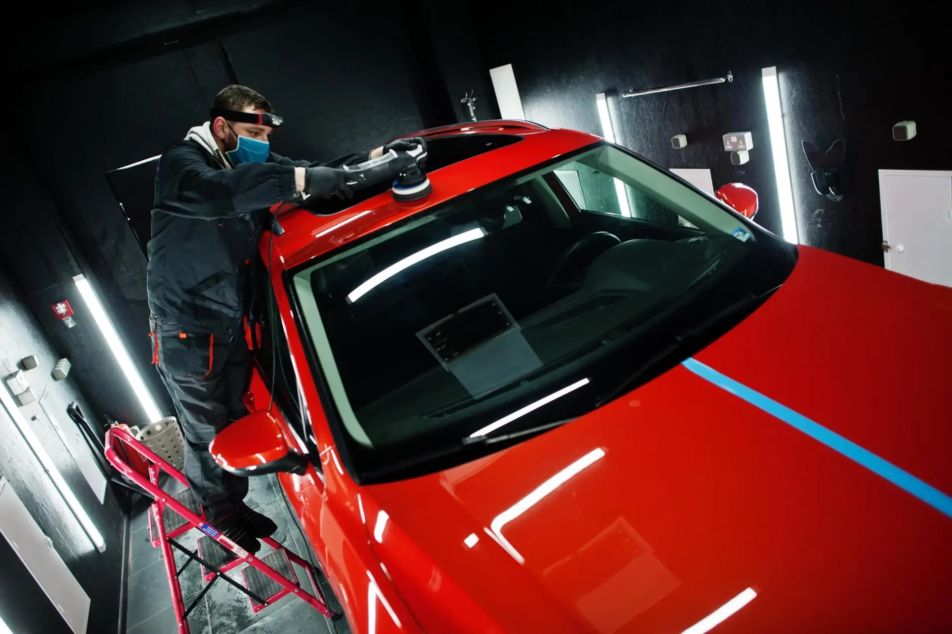 car-detailing-concept-man-face-mask-with-orbital-polisher-repair-shop-polishing-roof-orange-suv-car_web.webp